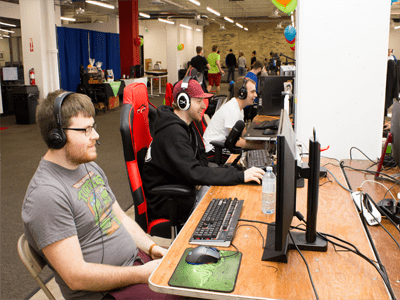 Three participants sitting at desks playing video games.